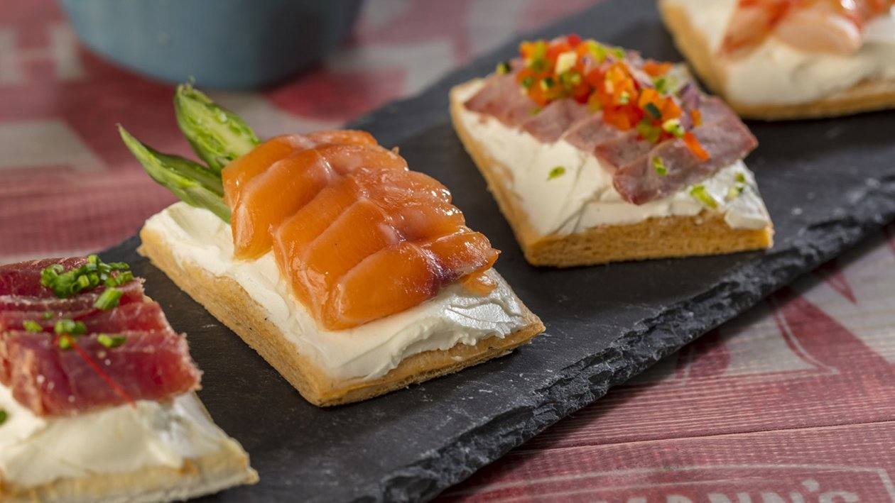 recipe image Montaditos de queso crema Rama con salmón, gamba, mojama y bresaola
